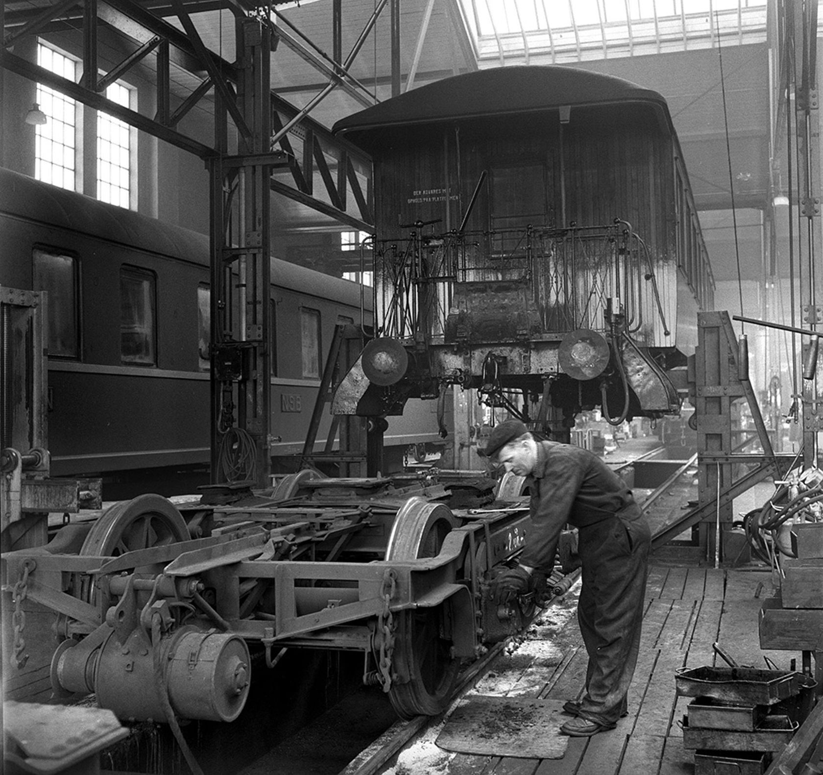 Bildet er fra Sundland Verk i 1957. En arbeider arbeider i verkstedet.