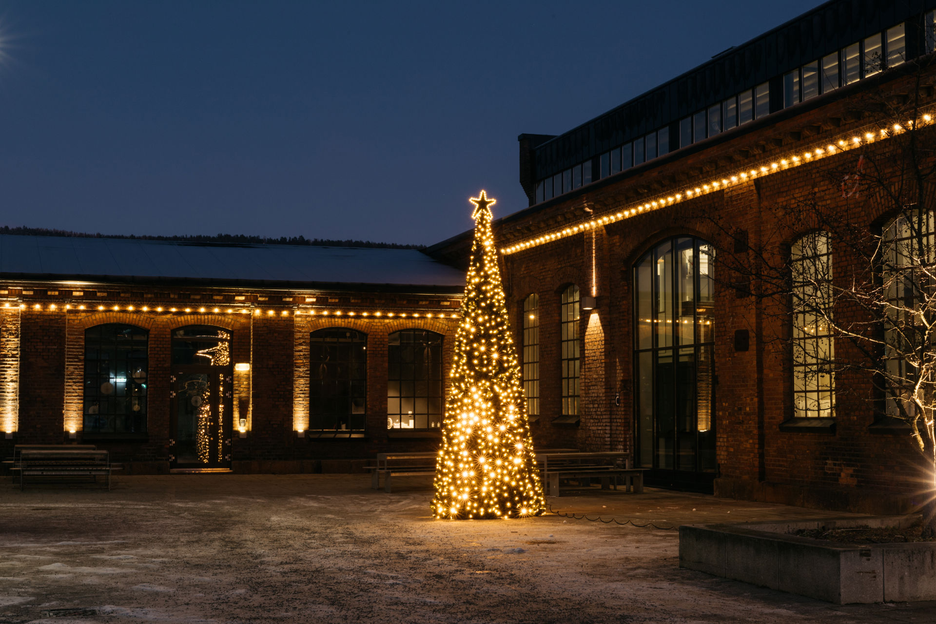 Et opplyst juletre midt på et torg