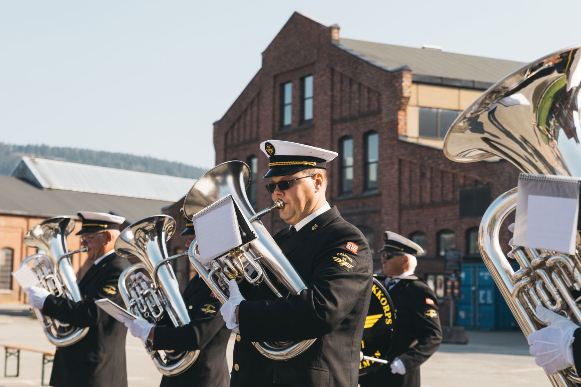 Medlemmer fra korps spiller på blåseinstrument